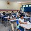 Foto de uma sala de aula com mais de 20 alunos, todos estão sentados em carteiras enquanto escrevem. Eles usam a farda da rede estadual de Pernambuco