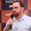Imagem de Técio Teles falando ao microfone com um rosto sério ao fundo está escrito NOVO-PE