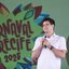 João Campos fala no microfone em pé, ao fundo logo do Carnaval do Recife 2025