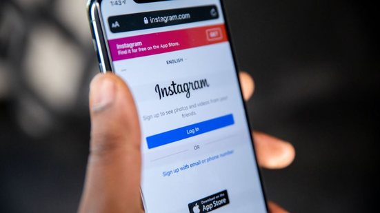 Imagem de uma pessoa segurando o celular com o Instagram aberto na tela - Solen Feyissa/Unsplash