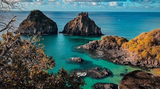 Imagem do mar e montanhas rochosas em Fernando de Noronha