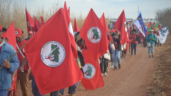 Bandeiras do MST em protesto por terra em estrada de terra
