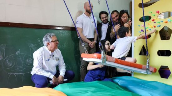 Padilha sorri enquanto observa criança brincar