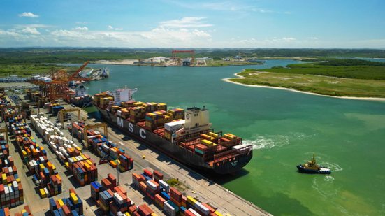 Imagem aérea do Porto de Suape, com navio atracado e centenas de conteineres na área de carga e descarga.