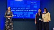 A diretora-presidente Ana Luiza Ferreira em Brasília, acompanhada pela equipe da Adepe, ao fundo, telão com tema do encontro:Workshop Internacional de Cabos Submarinos e Data Centers, evento do Ministério das Comunicações que trata da infraestrutura digita