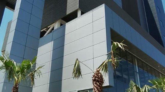 Parte externa de prédio com estilo moderno em cores branco e cinza