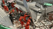 Escombros com bombeiros ao redor