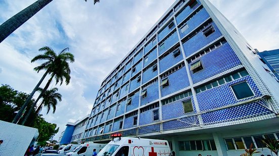 Visão do prédio do Imip de baixo para cima, ao lado ambulâncias