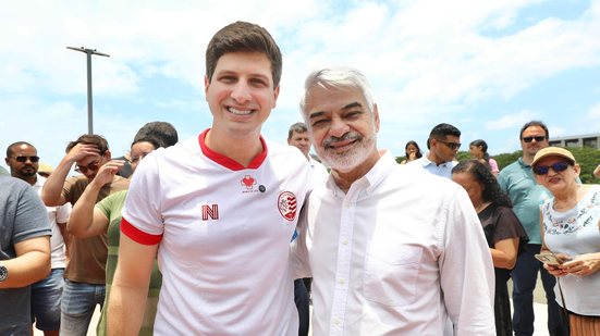João Campos e Humberto Costa sorriem, ao fundo diversas pessoas