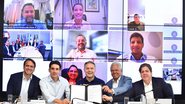 Silvio Costa Filho, Renan Filho e outros seguram documento enquanto ao fundo estão um mosaico com várias câmeras ligadas, então João Campos, Raquel Lyra e outros