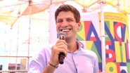 João Campos sorri com microfone na mão