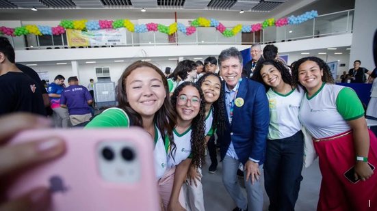 Lula Cabral tira selfie com meninas jovens com farda verde