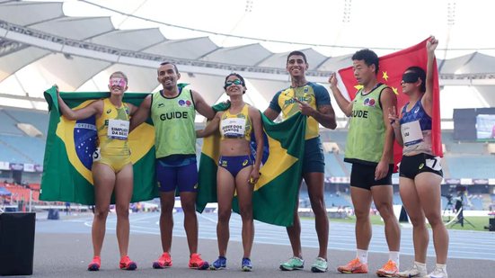 Atletas brasileiros e chineses segurando bandeiras de seus países