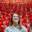 Raquel Lyra sorrindo de costas para uma plateia de bombeiros que gritam