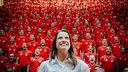 Raquel Lyra sorrindo de costas para uma plateia de bombeiros que gritam