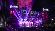 Show com luzes escrito "rec'n'play" diversas pessoas ao redor