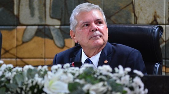 Ricardo Paes Barreto, de terno, olha para o lado