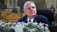 Ricardo Paes Barreto, de terno, olha para o lado