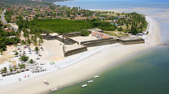 Visão de cima da ilha de itamaracá, com mar azul e áreas verdes