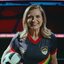 Marília Arraes segura uma bola enquanto usa camisa de time