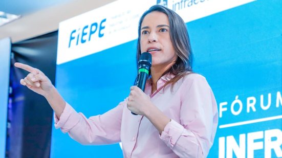 Raquel Lyra fala em microfone, ao fundo telão mostra a logo da fiepe