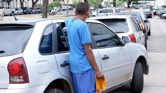 Homem segura flanela ao lado de carro