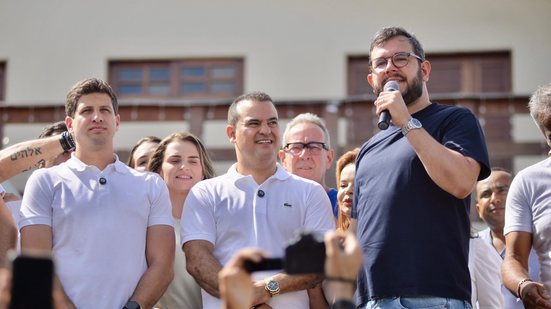 Gabriel Porto fala em microfone ao lado de João Campos e Eduardo Lira, ao fundo Marília Arraes e Álvaro Porto