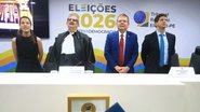 Raquel Lyra, Fernando Cerqueira, Ricardo Paes Barreto e João Campos em posição de respeito para o hino. Ao fundo escrito "Eleições 2026" e símbolo do TRE