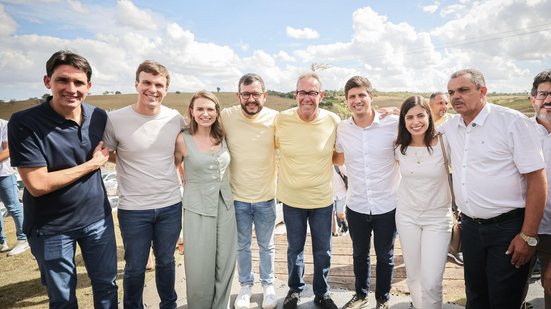 Abraçados lado a lado estão Silvio Costa Filho, Miguel Coelho, Marília Arraes, Gabriel Porto, Álvaro Porto, João Campos, Tabata Amaral e um homem de cabelo grisalho e pele bronzeada. Eles estão em área externa