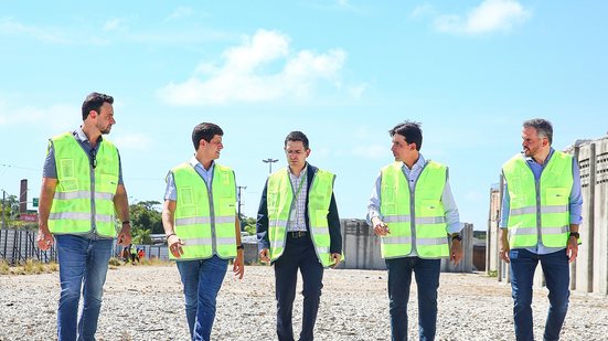 Cinco homens com colete de segurança em uma obra. Dois deles são João Campos e Silvio Costa Filho