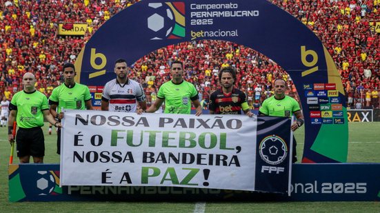 Jogadores de Sport e de Santa e arbitragem seguram cartaz escrito: "Nossa paixão é o FUTEBOL, nossa bandeira é a PAZ!"