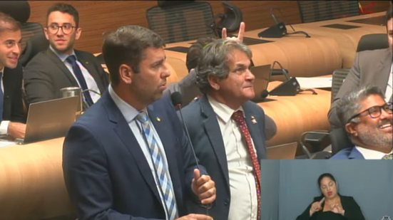 Eduardo Moura faz simbolo de chifre com a mão na cabeça de Chico Kiko enquanto Samuel Salazar fala e Rinaldo Júnior ri. Estão na plenária