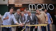 João Campos junto com vários homens brancos de cabelos grisalhos cortam juntos fita de inauguração. Ao lado está Victor Marques. Todos sorriem. Ao fundo prédio tem escrito "Motto"