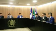 Antonio Coelho, Renato Antunes Gustavo Gouveia João de Nadegi e João de Nadegi sentados em mesa com símbolo da ALEPE, ao fundo bandeiras de Pernambuco, Brasil e Recife