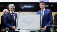 Humberto Costa e João Campos seguram placa escrito cidadão do recife e o nome de humberto costa, ambos sorriem