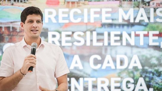 João Campos. Ao fundo, a frase "Recife mais resiliente a cada entrega"