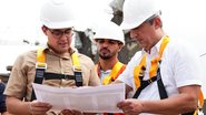 Victor Marques e trabalhadores de obras olham para papel