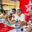 Carlos Veras fala em microfone. Bandeira do PT está pendurada. Diversas pessoas estão sentadas em frente a Carlos que está em mesa