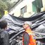 Victor Marques e agentes da Defesa Civil olham para lona