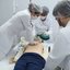 Estudantes de saúde praticando técnicas de salvamento em boneco