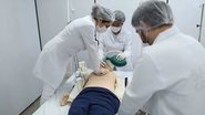 Estudantes de saúde praticando técnicas de salvamento em boneco