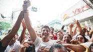 João Campos com o punho direito para cima, em meio à multidão