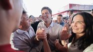 João Campos cumprimenta homem de camisa vermelha enquanto sorri