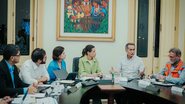 Waldez Góes fala, Raquel Lyra, Priscila Krause, Túlio Gadelha e Fabrício Marques olham para Waldez. Todos estão sentados em mesa de reunião no Palácio do Campo das Princesas