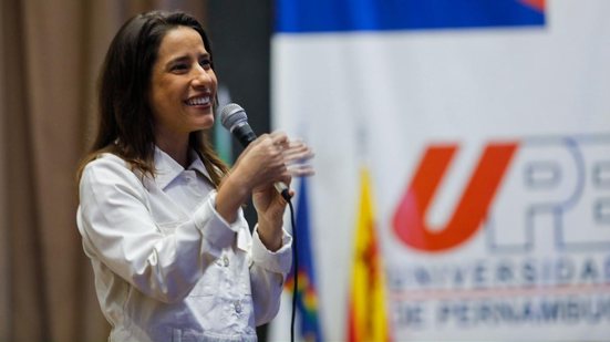 Raquel Lyra fala no microfone. Símbolo da UPE no fundo