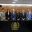 Lado a lado sorrindo em frente ao escudo da Alepe que fica em bancada estão Diogo Moraes, Frederico Maranhão, Carlos Porto Filho, Roberta Araújo Machado, Alberto Feitosa, Paula Pavani, Edson Vieira, João Paulo, Débora Almeida e Eriberto Filho