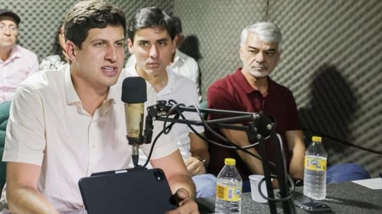 João Campos fala ao microfone durante entrevista