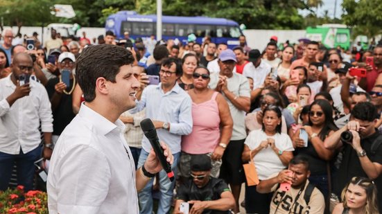 João Campos fala ao microfone para multidão