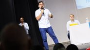 Victor Marques, em pé, falando ao microfone