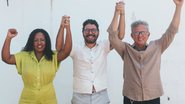 Alice Gabino, Ivan Moraes e Paulo Rubem Santiago com as mãos unidas e levantadas. todos sorriem